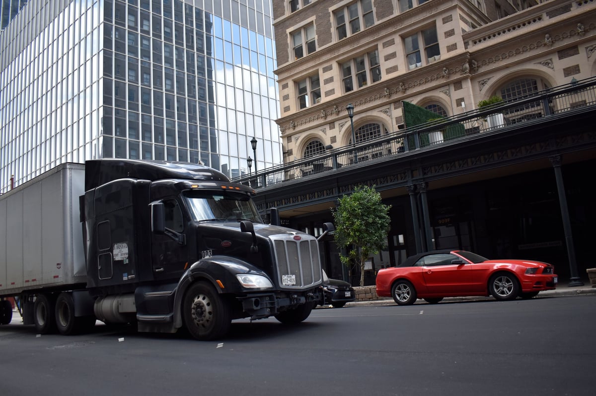 Peterbilt semi-truck cruising through a downtown financial district