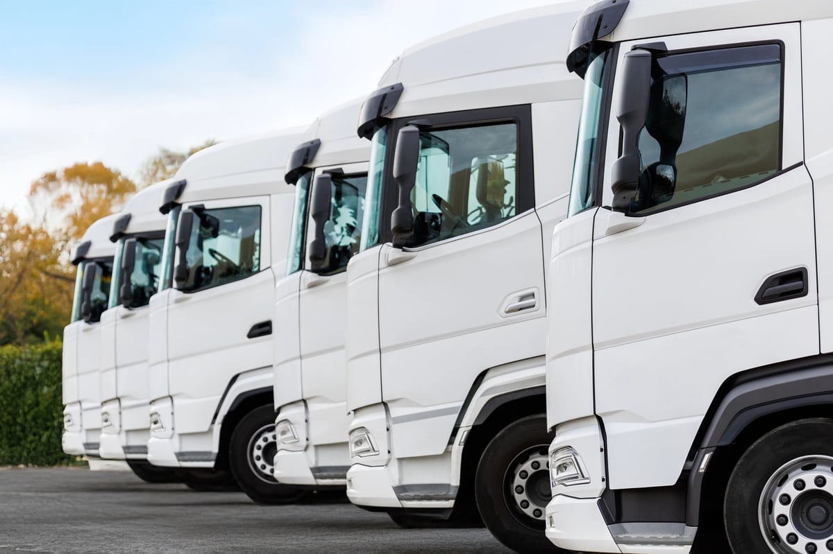 Fleet of modern trucks parked in a row outdoors
